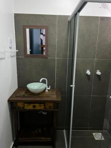 a bathroom with a sink and a shower at Pousada Silvestre in Tramandaí +39 photos