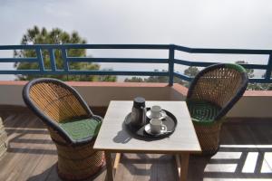 a table and two chairs on a balcony at Rudraa Himalayan Retreat in Hawālbāgh