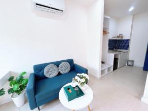 a living room with a blue couch and a table at Santo house in Thôn Trường Giang