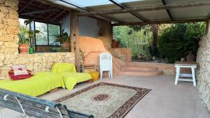 a patio with a couch and a table and chairs at Quinta Da Carvalheira Regenerative Coliving in Soure