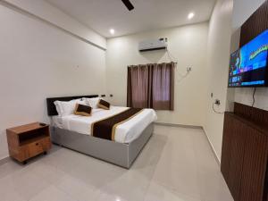 a bedroom with a bed and a flat screen tv at Thamira Grand palace in Agastīswaram