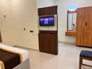 a hotel room with a tv and a bed at Thamira Grand palace in Agastīswaram