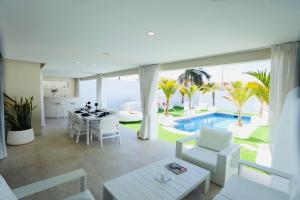 a living room with a table and chairs and a pool at Olivia Holidayhouse Maspalomas in Maspalomas