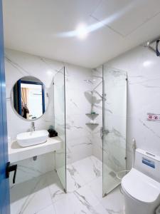 a white bathroom with a sink and a toilet at Santo house in Thôn Trường Giang