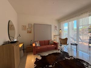 a living room with a red couch and a mirror at Appartamento Centovalli e Verzasca in Minusio