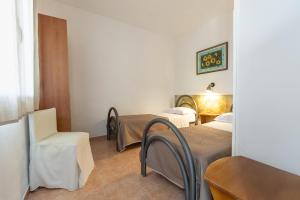 a room with two beds and a table and chairs at San Carlo - Terrazzo sul Mare con Ristorante e Pizzeria in Zambrone