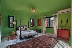a bedroom with green walls and a bed and a rug at Villa Samadhi - Luxury & Serenity in Marrakesh