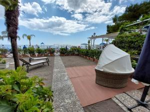 a patio with a table and a bench and the ocean at Sea suite positano in Positano