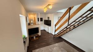a living room with a staircase and a flat screen tv at Amara in Siegburg