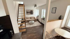 a stairway leading to a living room with a couch at Amara in Siegburg