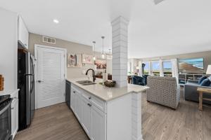 a kitchen and living room with a sink and a refrigerator at 1325 Pelican Watch Villa in Seabrook Island