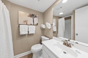 a bathroom with a sink and a toilet and a mirror at 1325 Pelican Watch Villa in Seabrook Island