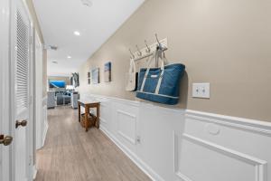a hallway with white cabinets and a blue purse on a shelf at 1325 Pelican Watch Villa in Seabrook Island