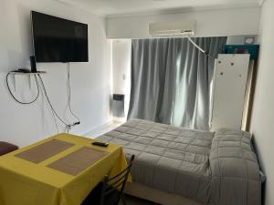 a bedroom with a bed and a table and a television at Shackleton in Wilde