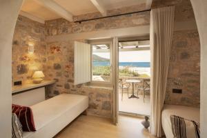 a bedroom with a bed and a view of the ocean at Porto Vitilo Boutique Hotel in Karavostasi +181 photos