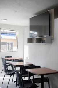 a classroom with tables and chairs and a tv on the wall at Hotel Ullanka in Encarnación
