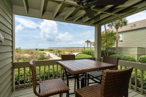 a patio with a table and chairs on a balcony at 1391 Pelican Watch Villa in Seabrook Island