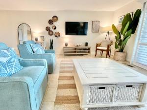a living room with blue couches and a table at 1391 Pelican Watch Villa in Seabrook Island