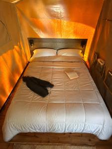 a bed in a tent with a black umbrella on it at Camping de Retourtour in Lamastre