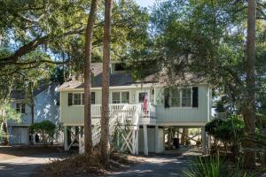 a house with a wrap around porch with trees at 546 Tarpon Pond Cottage in Seabrook Island