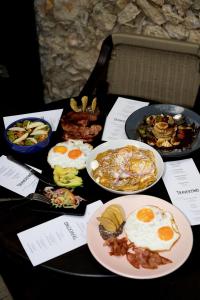 a table with plates of breakfast food on it at Hotel Travertino in Mérida