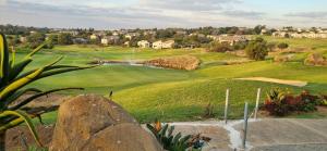 a view of a golf course with a green at Nestled sanctuary in Northriding +7 photos