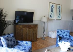 a living room with two chairs and a flat screen tv at 13106 Pelican Watch Villa in Seabrook Island