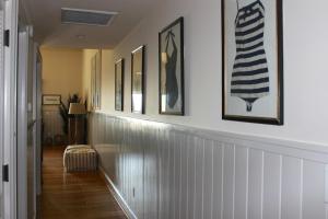 a hallway with a row of framed pictures on the wall at 13106 Pelican Watch Villa in Seabrook Island