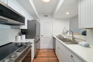 a white kitchen with a sink and a stove at 1306 Pelican Watch Villa in Seabrook Island
