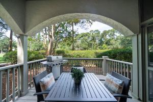 a porch with a table and chairs and a grill at 2501 Chateau by the Green in Seabrook Island