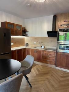 a kitchen with wooden cabinets and a sink at Apartamenty Riverside Lębork in Lębork