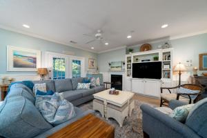 a living room with blue couches and a tv at 2501 Chateau by the Green in Seabrook Island +28 photos