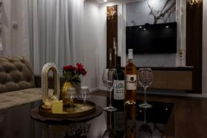 a living room with wine bottles and glasses on a table at Apartman Lux Bileca in Bileća +28 photos