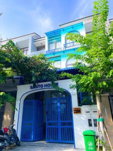 a blue and white building with a blue door at Santo house in Thôn Trường Giang