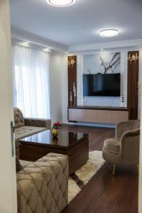 a living room with a tv and a couch and a table at Apartman Lux Bileca in Bileća