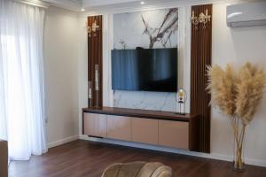 a living room with a flat screen tv on a wall at Apartman Lux Bileca in Bileća