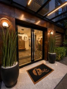 two potted plants in front of a building at Filadelfia Hotel in São Paulo
