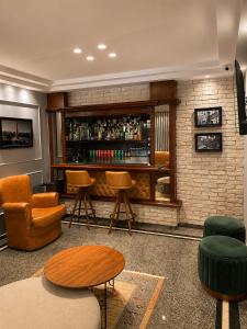 a room with a bar with chairs and tables at Filadelfia Hotel in São Paulo