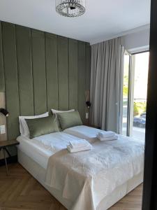 a bedroom with a large bed with two towels on it at Apartamenty Riverside Lębork in Lębork
