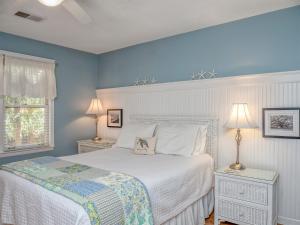 a bedroom with a white bed and blue walls at 550 Tarpon Pond Cottage in Seabrook Island
