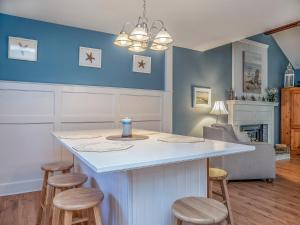 a kitchen with a white island with stools at 550 Tarpon Pond Cottage in Seabrook Island