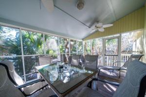 a dining room with a glass table and chairs at 550 Tarpon Pond Cottage in Seabrook Island