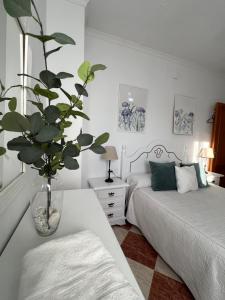 a bedroom with two beds and a vase with a plant at Casas PARAJE NATURAL in Zahara de la Sierra