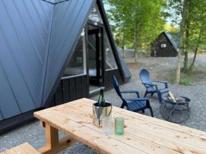 a bottle of wine sitting on a picnic table in front of a tent at Seneca Gorge Glamping in Hector +18 photos