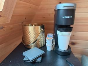a coffee maker sitting on a table with a cup at Seneca Gorge Glamping in Hector