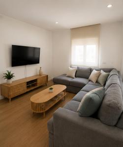 a living room with a couch and a tv at Waves beach house in Viana do Castelo