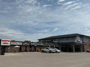 a building with two cars parked in a parking lot at Wheatland Hotel in Strathmore