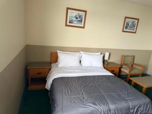 a bedroom with a bed and a desk and a chair at Wheatland Hotel in Strathmore +10 photos