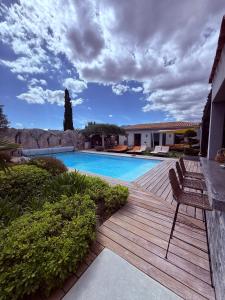a swimming pool with a wooden deck next to a house at Casa Avvena 1 in Lecci