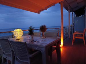 a table and chairs on a deck with the ocean at Aegean Infinite View-Beachfront Suite Pelion in Chorefto